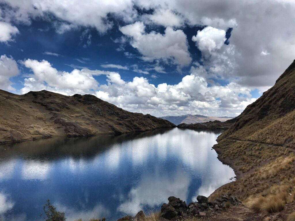 Cloud and blue sky reflected in the flat surface of a high mountain lake